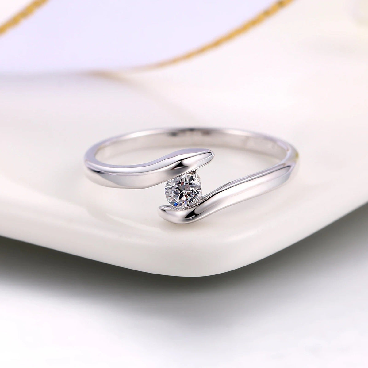 Bague avec barre incurvée et diamant éclatant au centre en or blanc