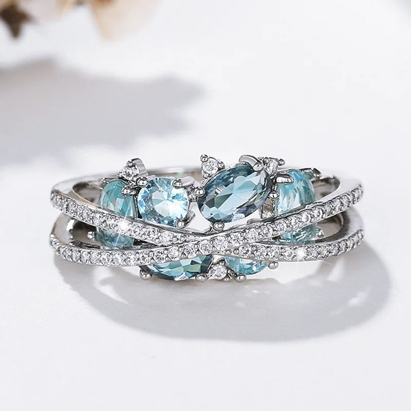 Bague avec croix et pierre précieuse bleue en or blanc