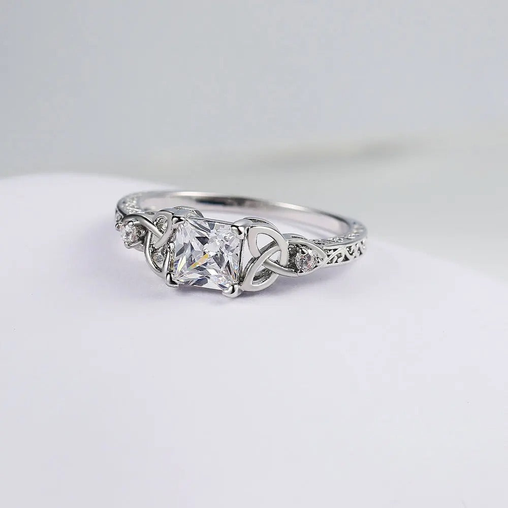 Bague avec design de nœud et pierre précieuse au centre en or