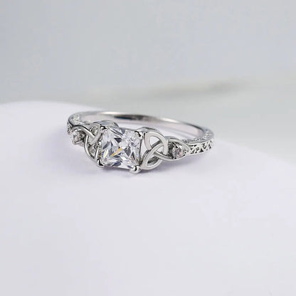 Bague avec design de nœud et pierre précieuse au centre
