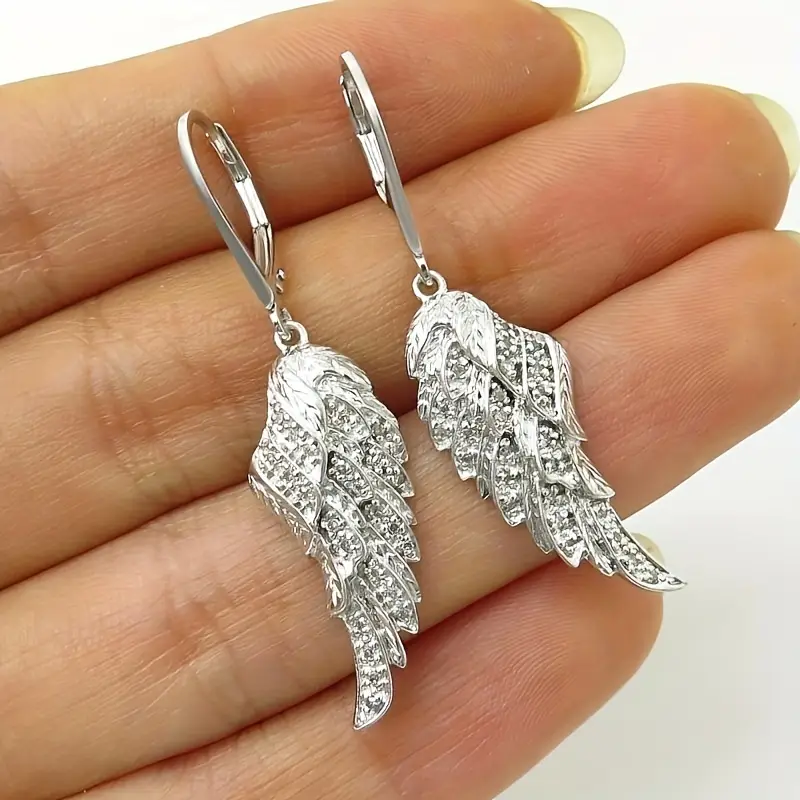 Boucles d'oreilles avec des ailes scintillantes en or blanc