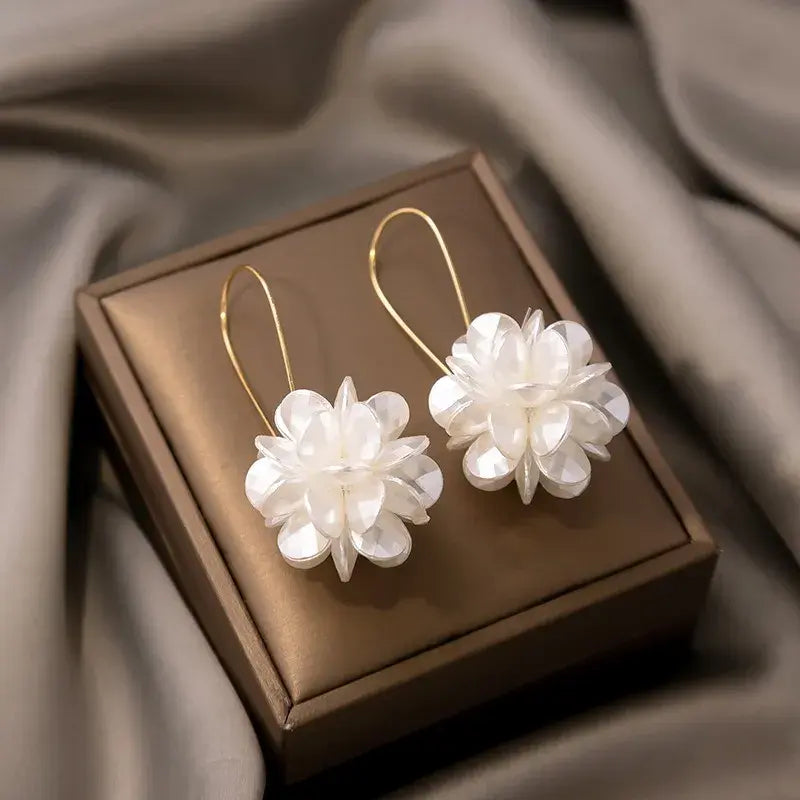 Boucles d'oreilles pendantes avec fleurs blanches en or
