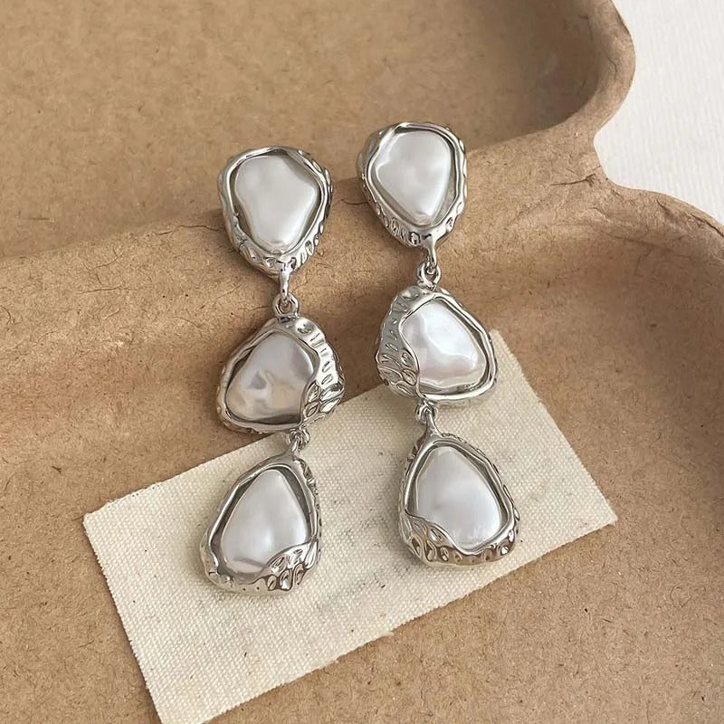 Boucles d'oreilles triangulaires avec des marguerites en or blanc