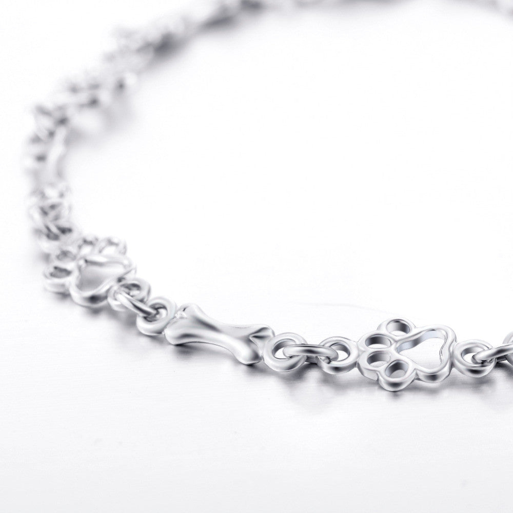 Bracelet avec pattes de chien suspendues et Os Brut, Édition limitée en or blanc