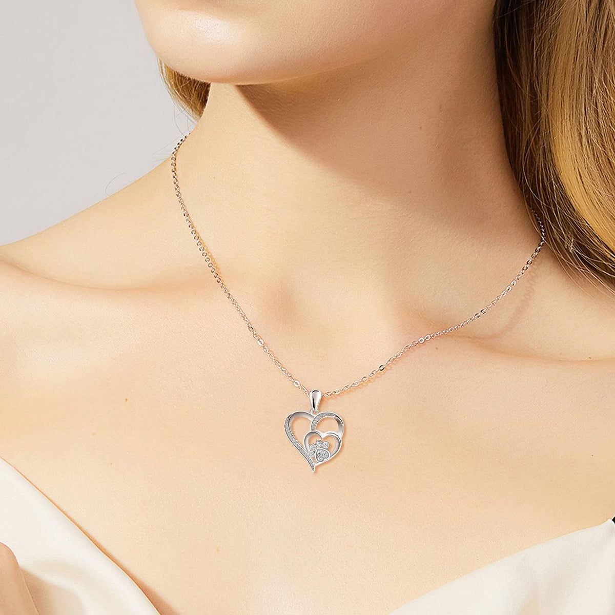Collier avec patte et cœur à brillants en or blanc